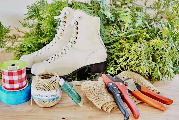 White ice skates, evergreens and ribbons for decorating a mailbox.