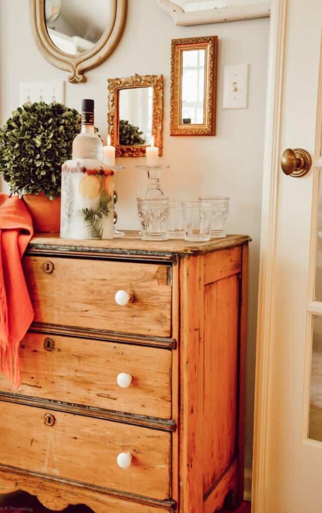 Vintage wood dresser as an beverage station with DIY ice bucket and vintage glassware.