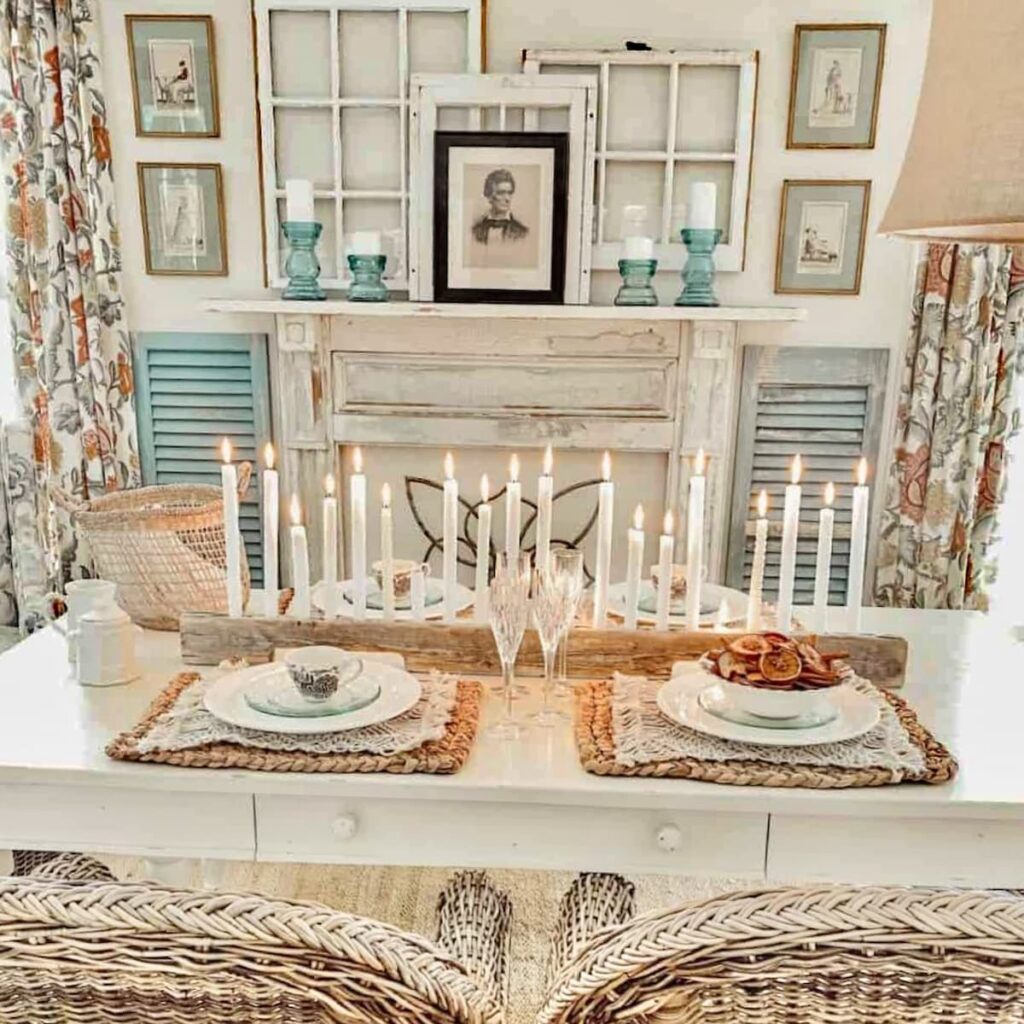 Vintage style dining room with candle centerpiece and faux mantel display with Sherwin Williams Navajo White painted walls.