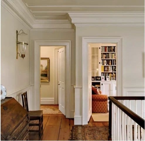 Sherwin Williams Navajo White Paint Interior painted home in bedroom hallway with wooden flooring and white trim.