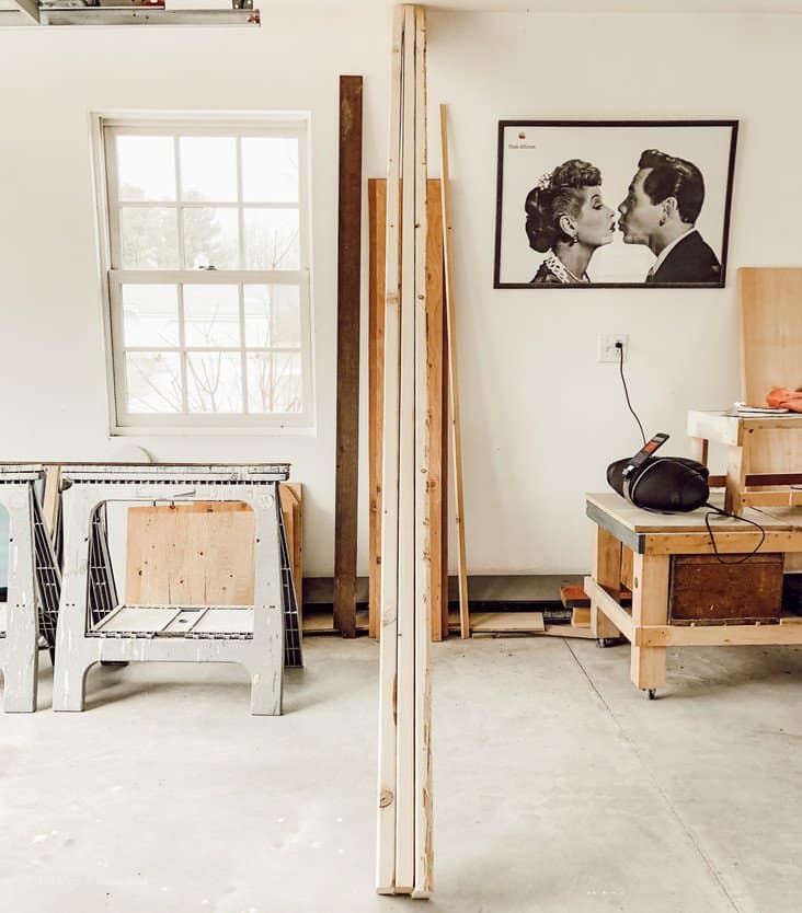 Three large wood boards leaning up against garage wall.