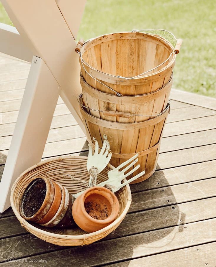 Stack of baskets and terracotta pots at the base of an outdoor table.