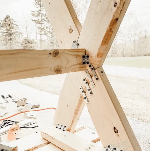 Close up of bolts and plates on legs of diy garden table.