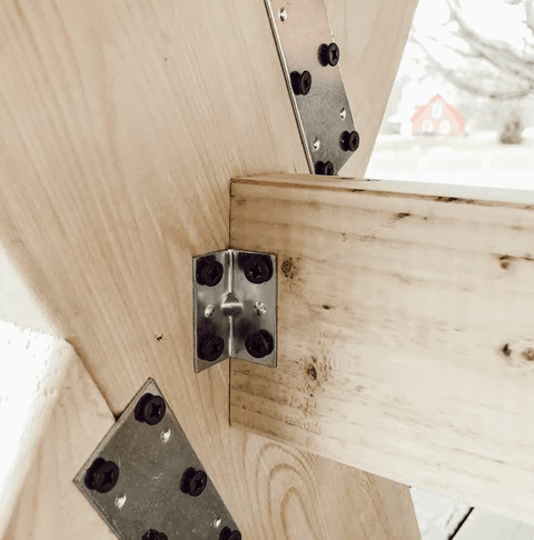 Close up of bolts and plates on legs of diy garden table.