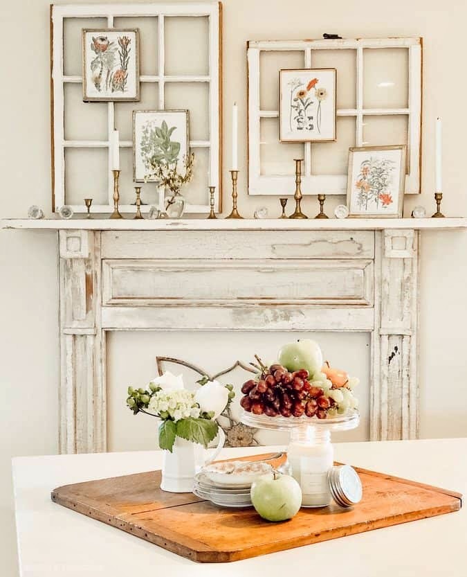 Vintage mantel in white with salvaged windows and botanical print display in dining room.