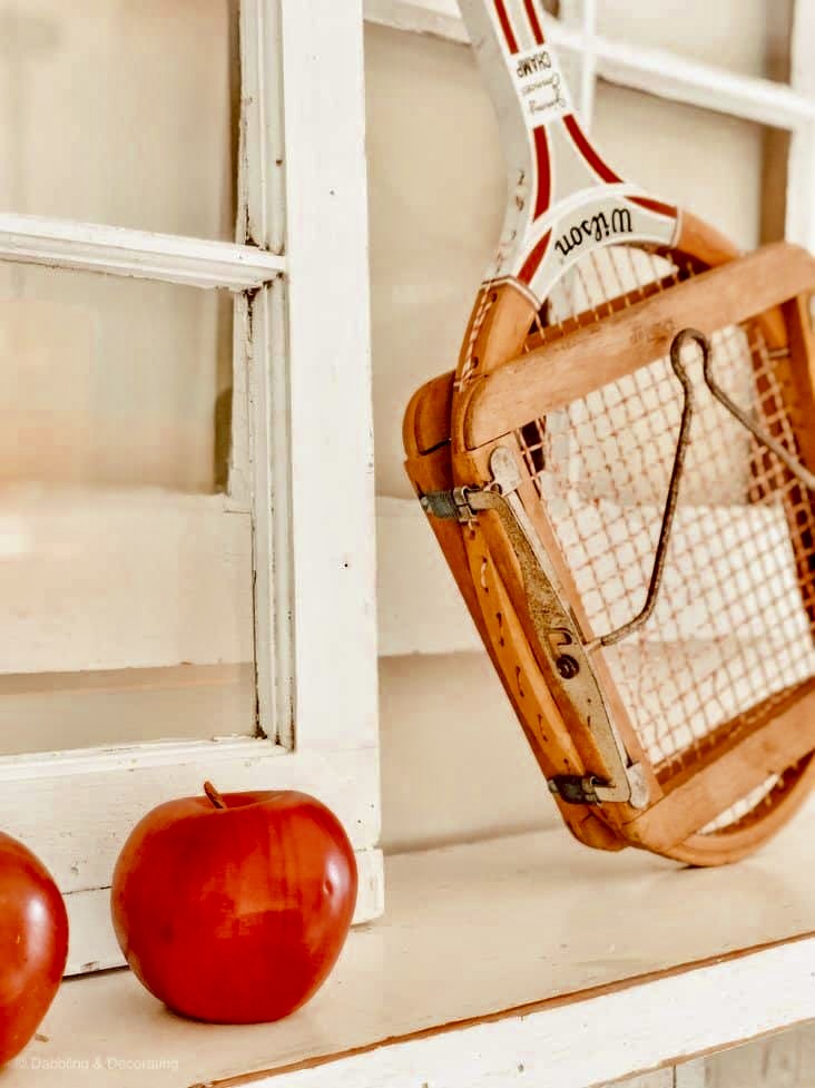 Vintage Tennis racket with red decor apple on Mantel