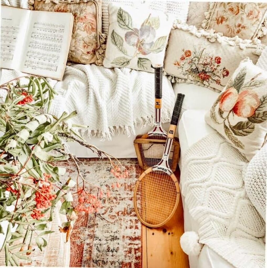 Winter white decorations with needlepoint pillows and soft colored touches in living room.