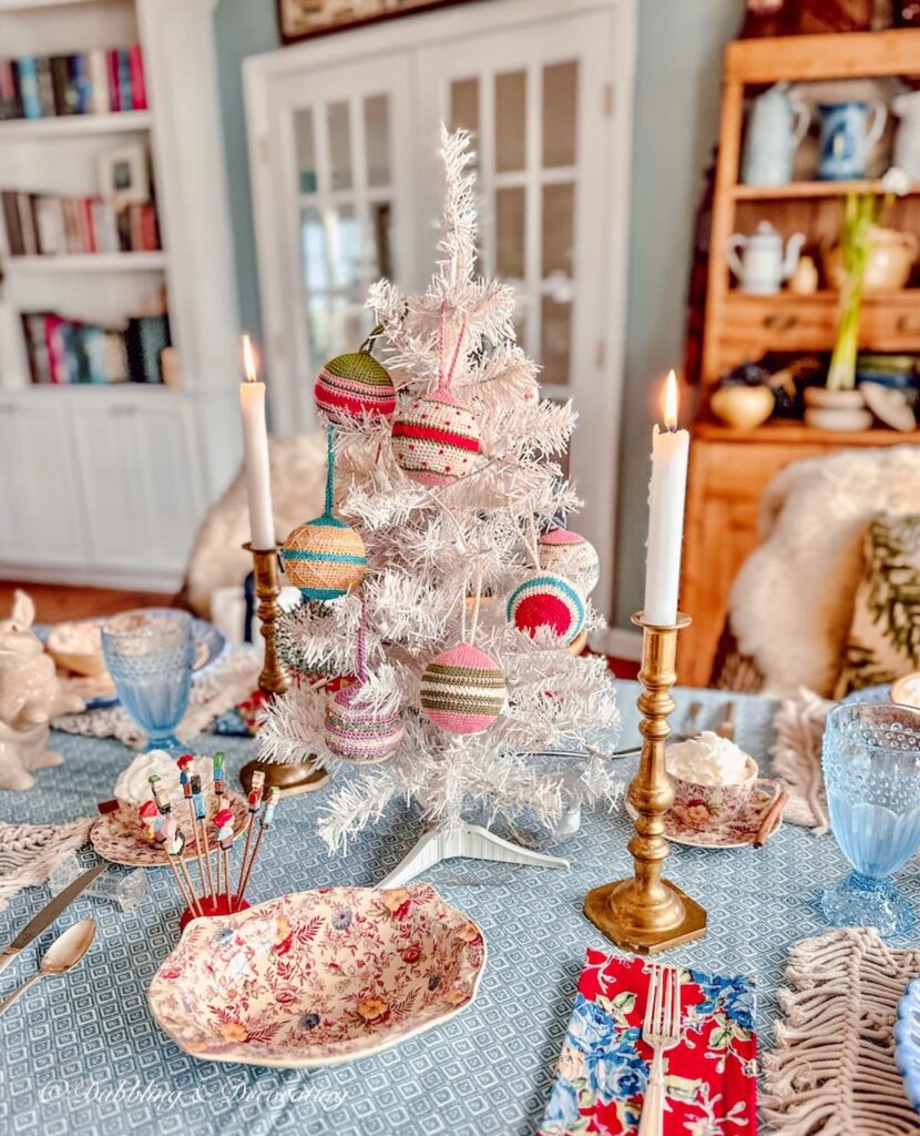 Vintage winter white decorations on Christmas table setting with vintage white Christmas tree as table centerpiece.