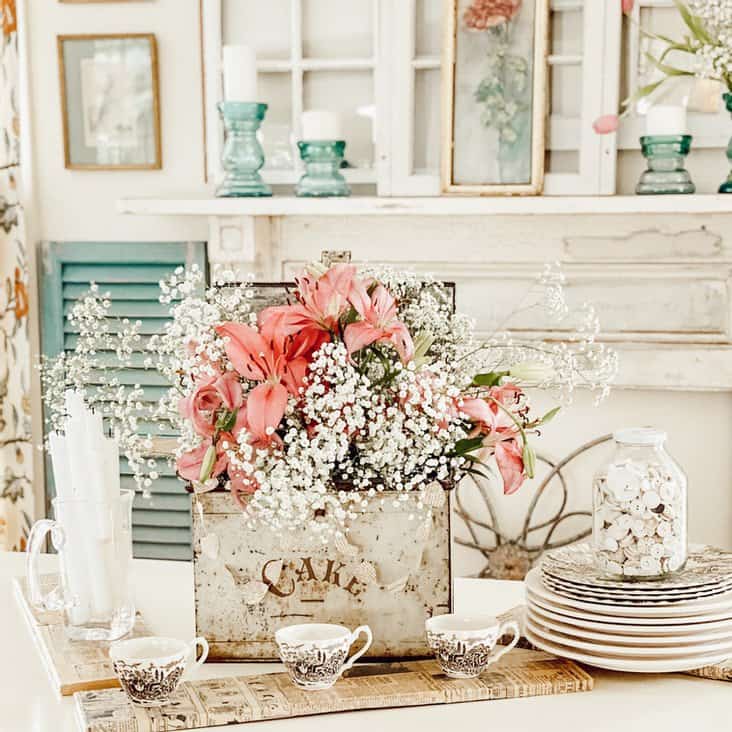 Valentine Centerpiece in in vintage cake tin with pink flowers and transferware in farmhouse style dining room.