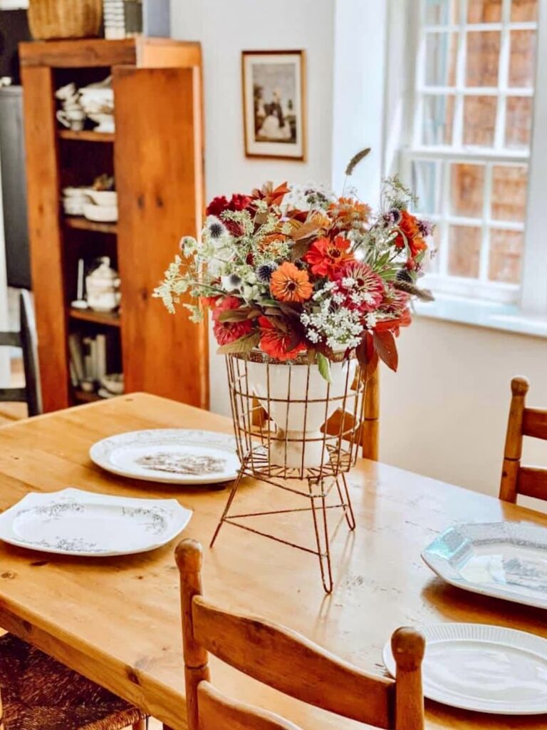 Vintage centerpiece with vibrant wildflowers on antique table in vintage style home.