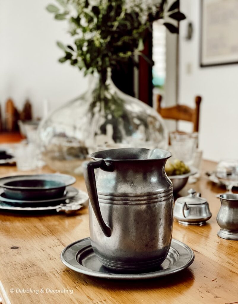 Pewter pitcher on primitive styled table setting.