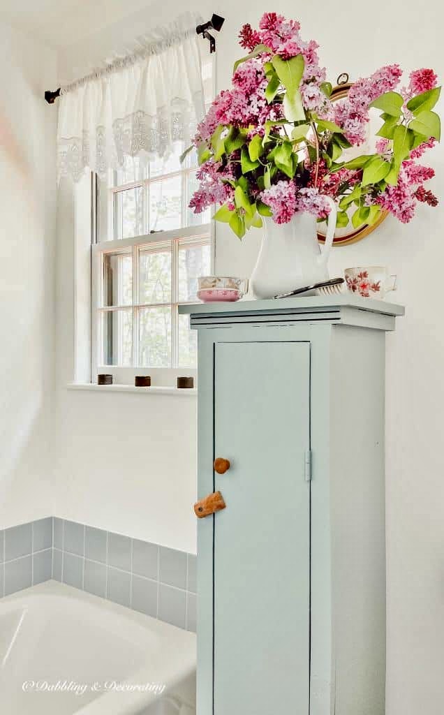 Purple Lilac Bouquet in white pitcher in bathroom