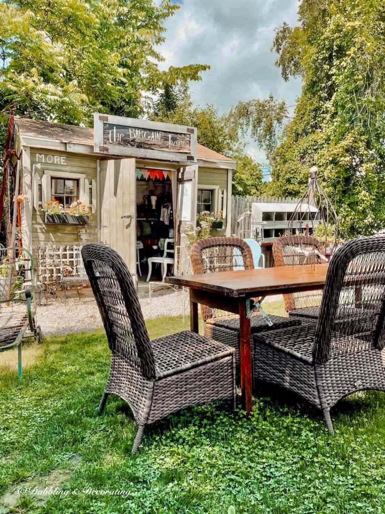 Vintage wooden wallpaper table with wicker chairs at outdoor flea market.