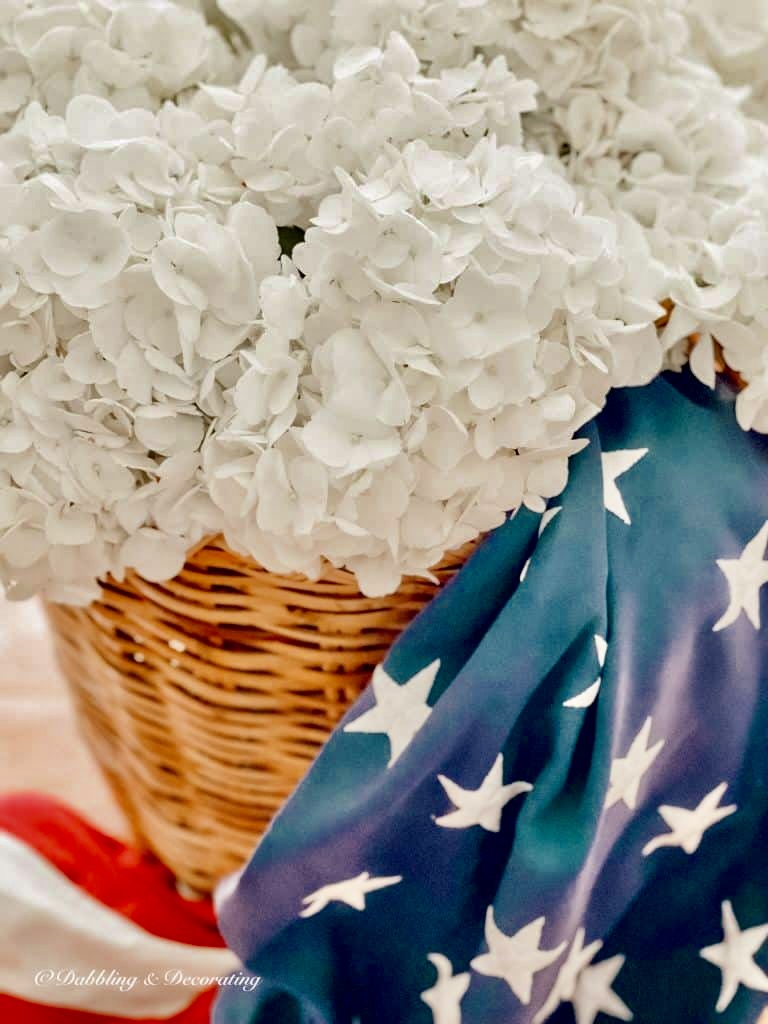 White hydrangeas with red, white, and blue USA Flag in Basket