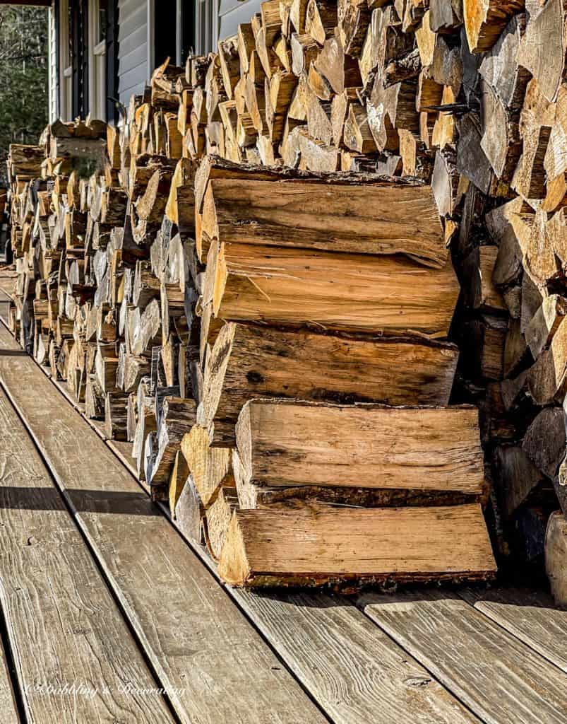 Wood pile on porch of house.