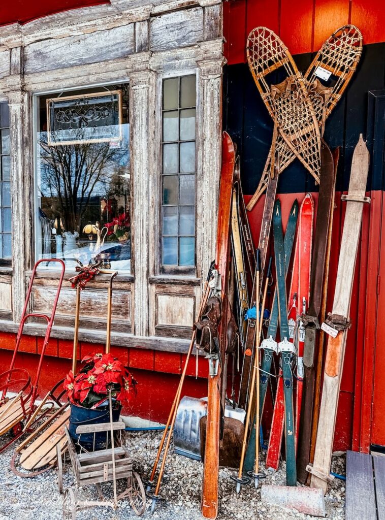 Pairs of vintage skis leaning up outside of an antique store in Vermont.