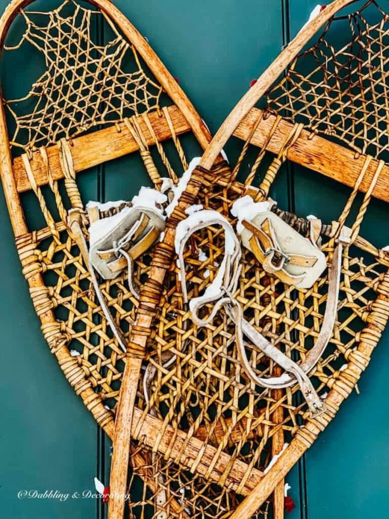 Antique wooden snowshoes on green door.