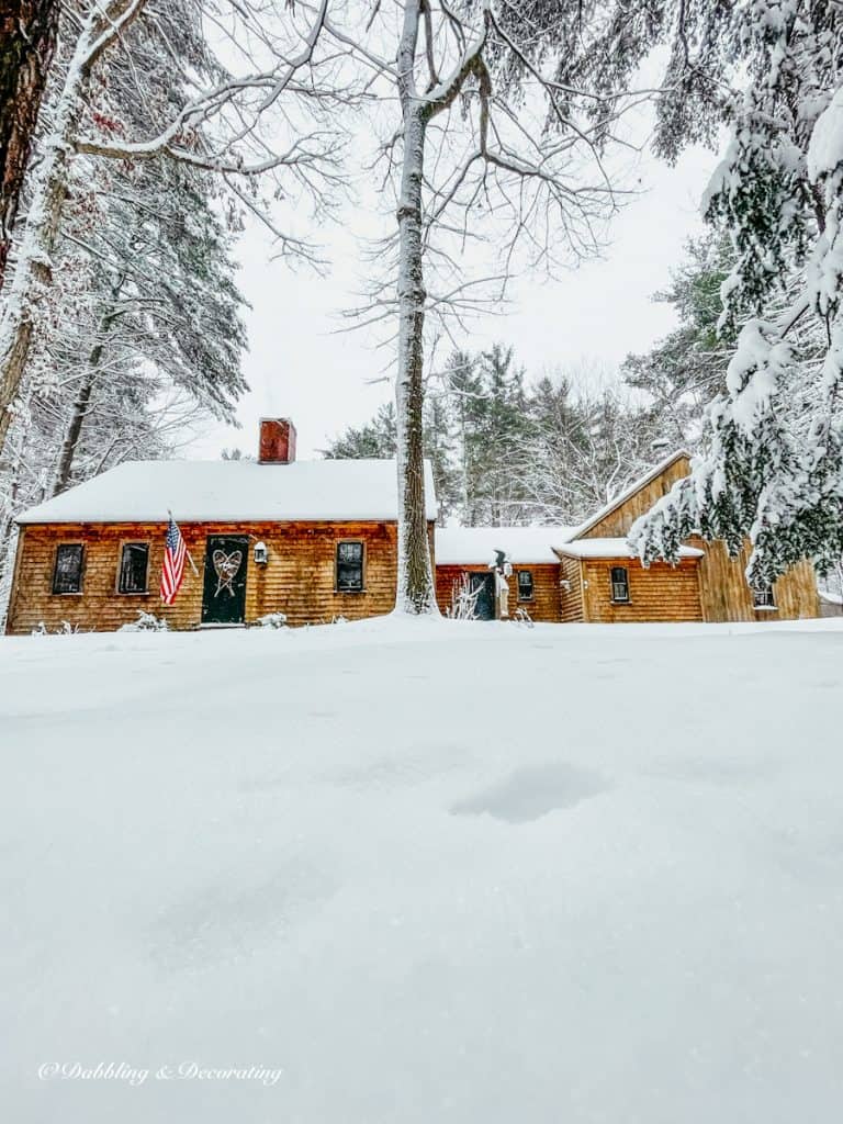 Rustic charming cedar shakes home in Maine after a large snow storm.