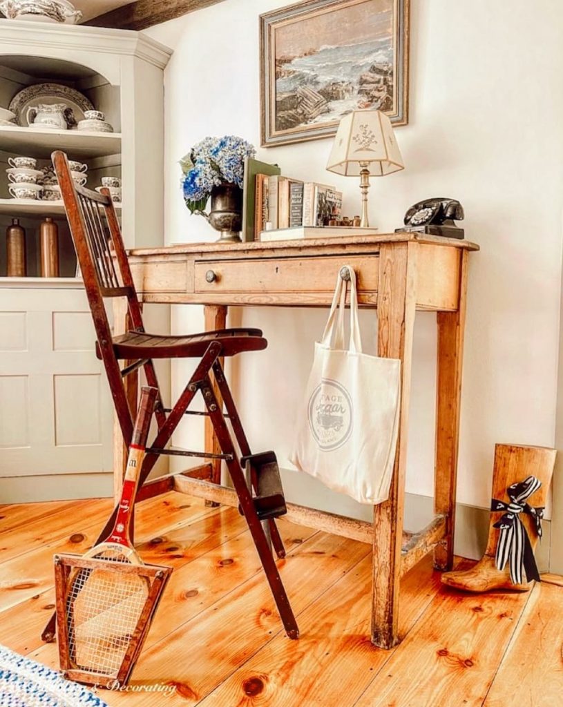A vintage wooden desk with a tennis racket on it.