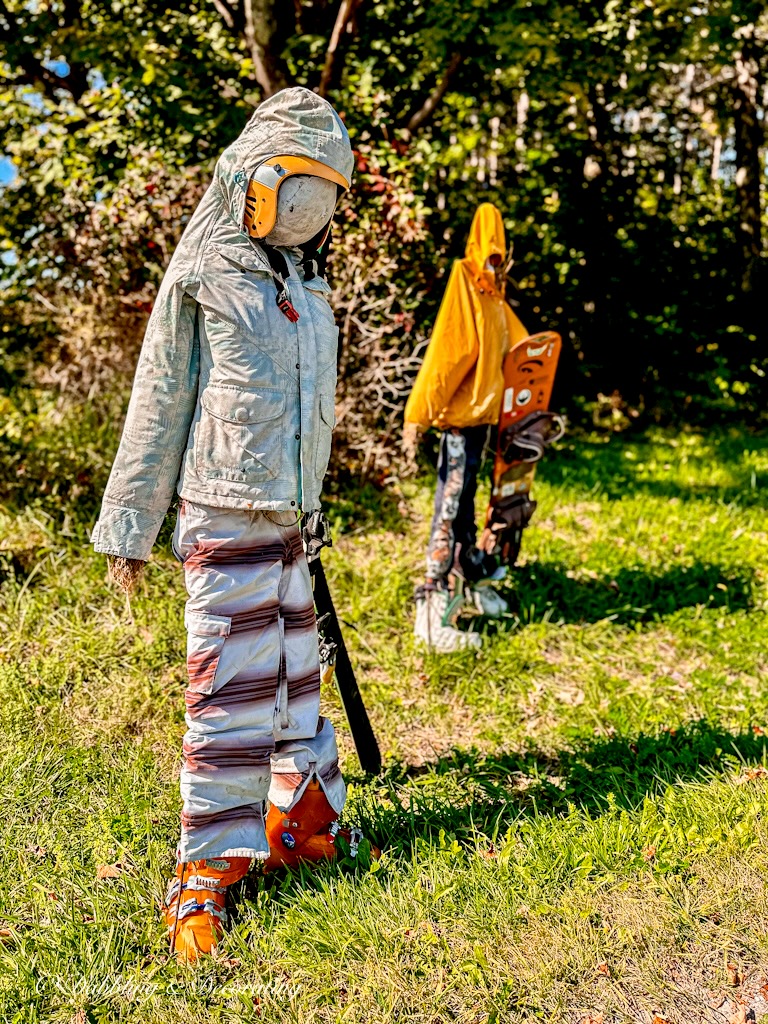 Female and Male funny scarecrows dressed as snowboarders.