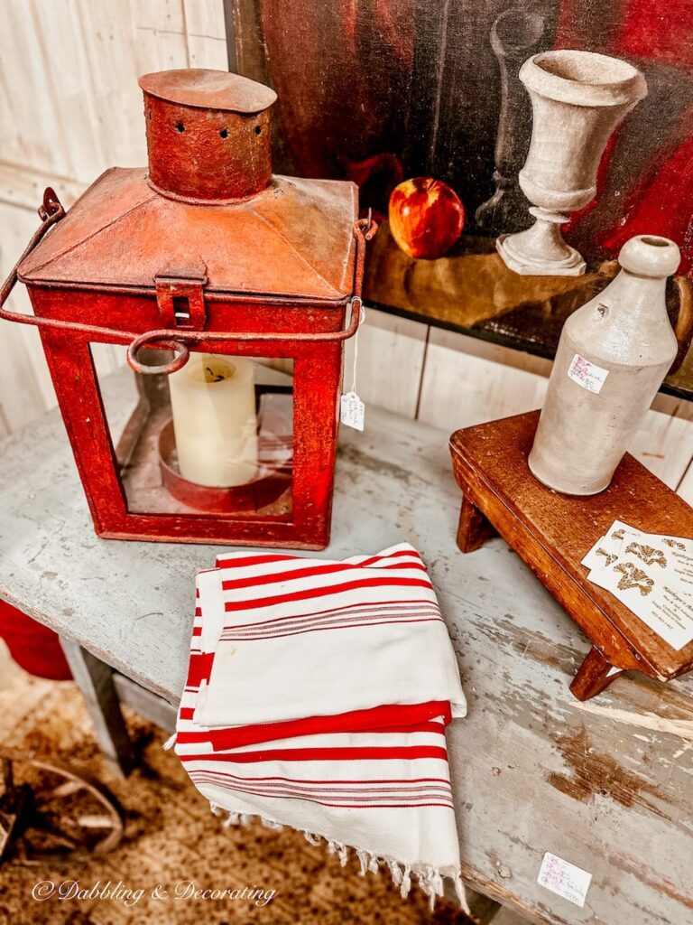 A vintage red lantern and red and white vintage towels in antique store.