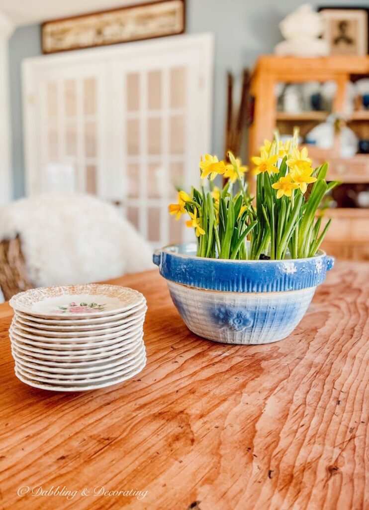 blue stoneware bowl with daffodils and plates.