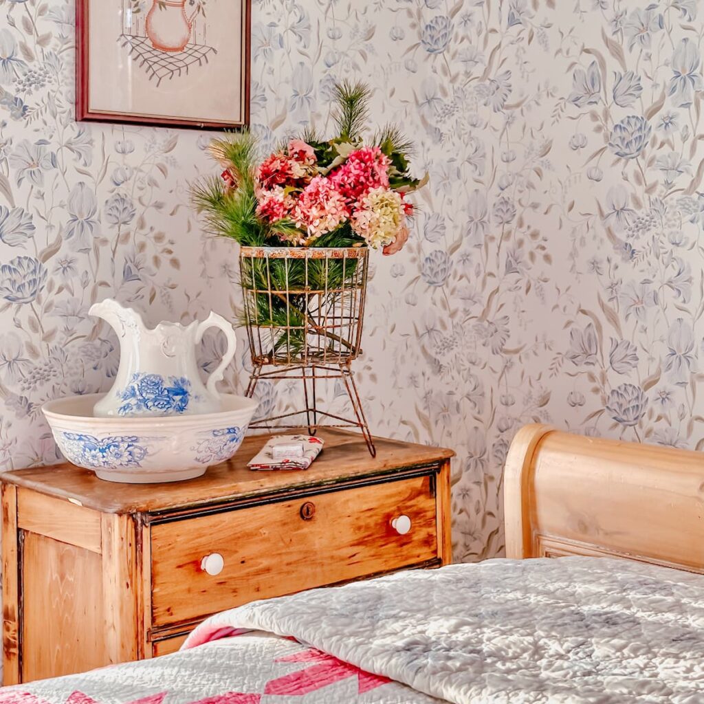 Foraged fall bouquet displayed in antique metal basket on bedroom dresser vintage style.