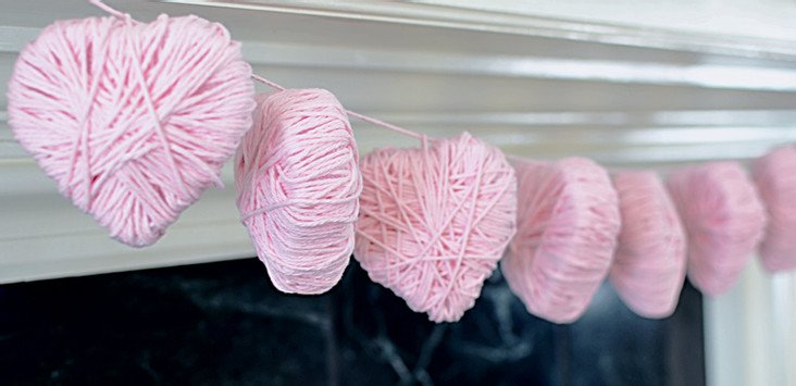 DIY heart garland for Valentine's Day hanging from fireplace mantel.