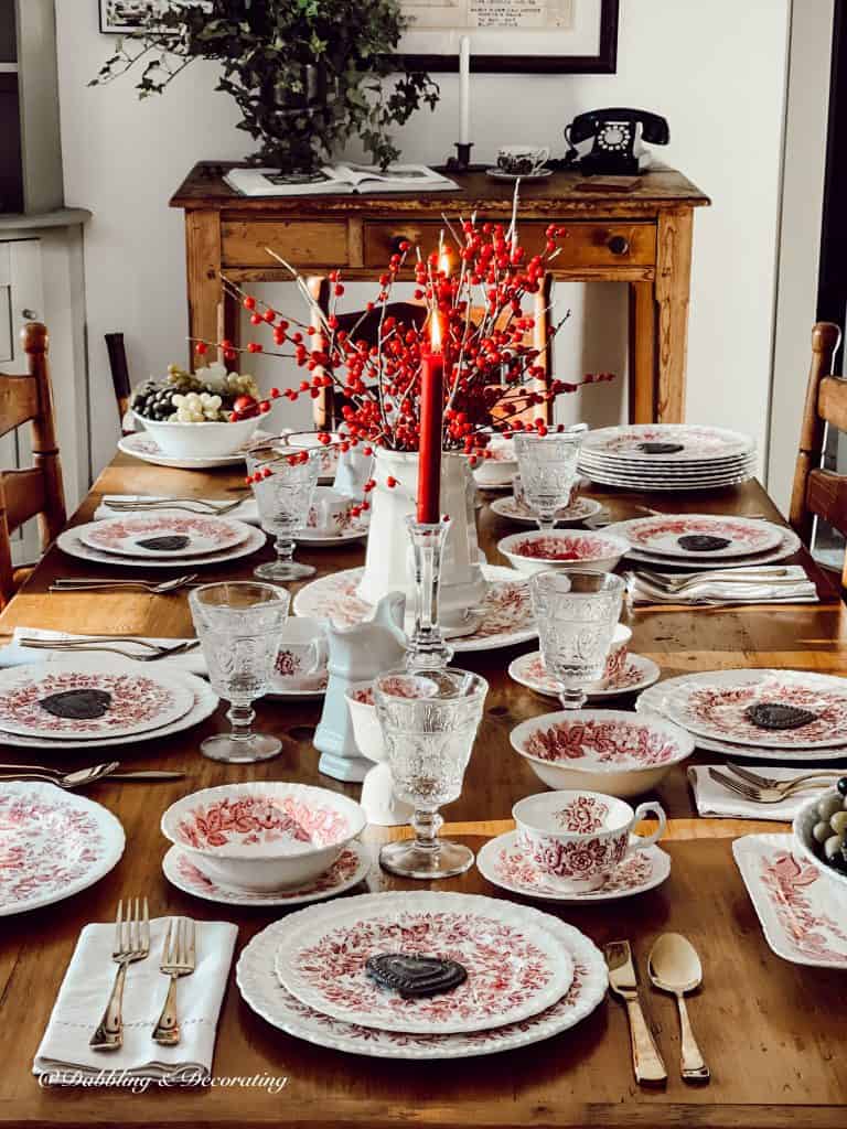 Romantic table setting with pink and white dishes and Winterberry vintage style centerpiece for Valentine's Day.