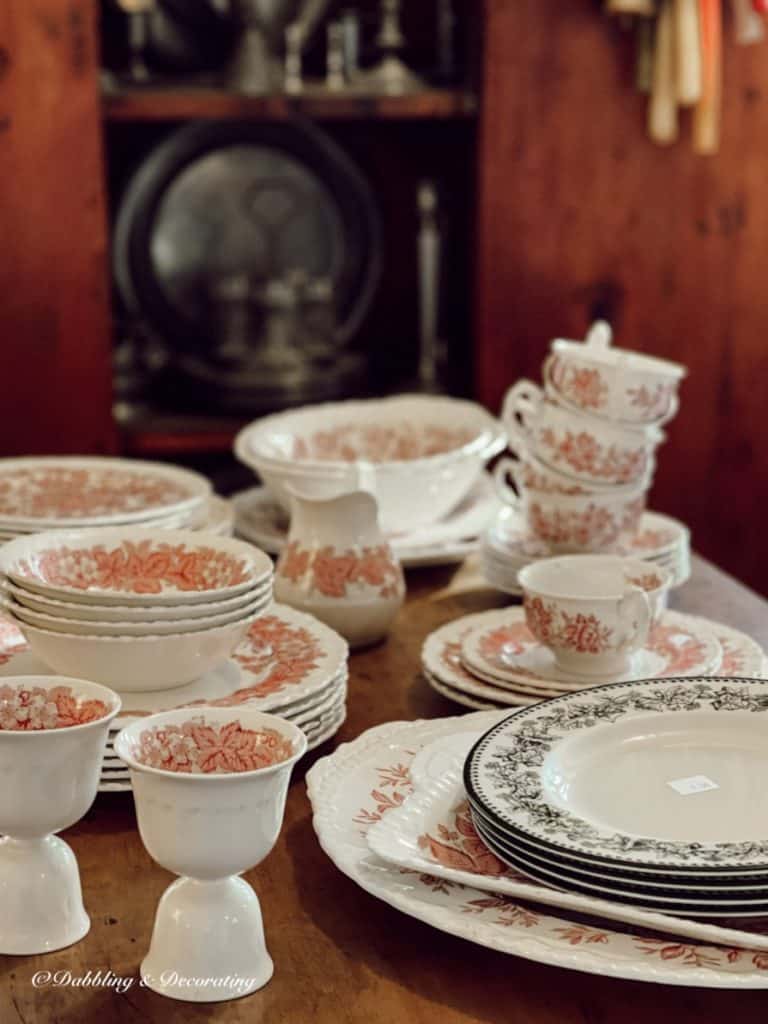 Collection on pink and white vintage dishes on table.