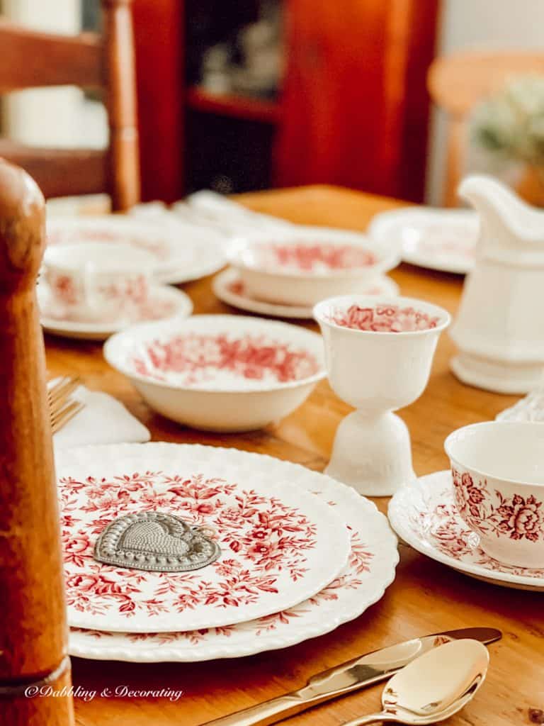 Pink and white Romantic table setting for Valentine's Day with vintage dishes.