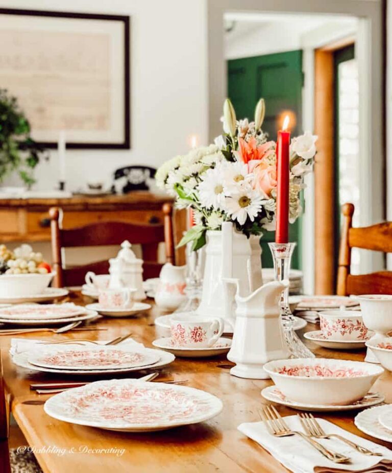 Romantic Table setting with pink and white vintage dishes in antique styled dining room.