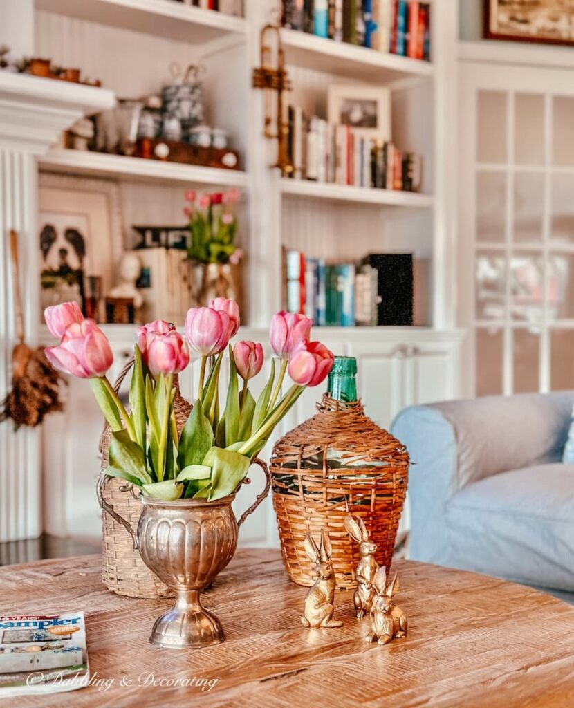 Pink tulip arrangements on coffee table in eclectic decor.