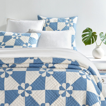 Blue and White Quilt on Bed in Bedroom.