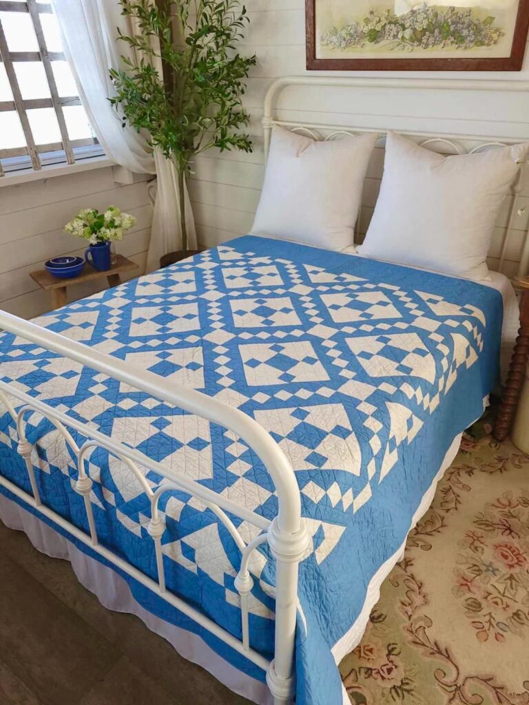 Blue and White Vintage Quilt on bed in bedroom.