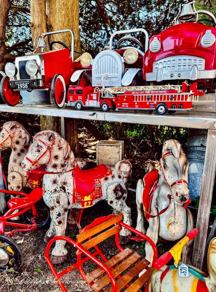 Antique children's fire trucks and horses at barn sale in Maine.