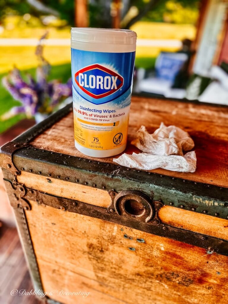 Clorox Disinfectant wipes on antique trunk with rag.