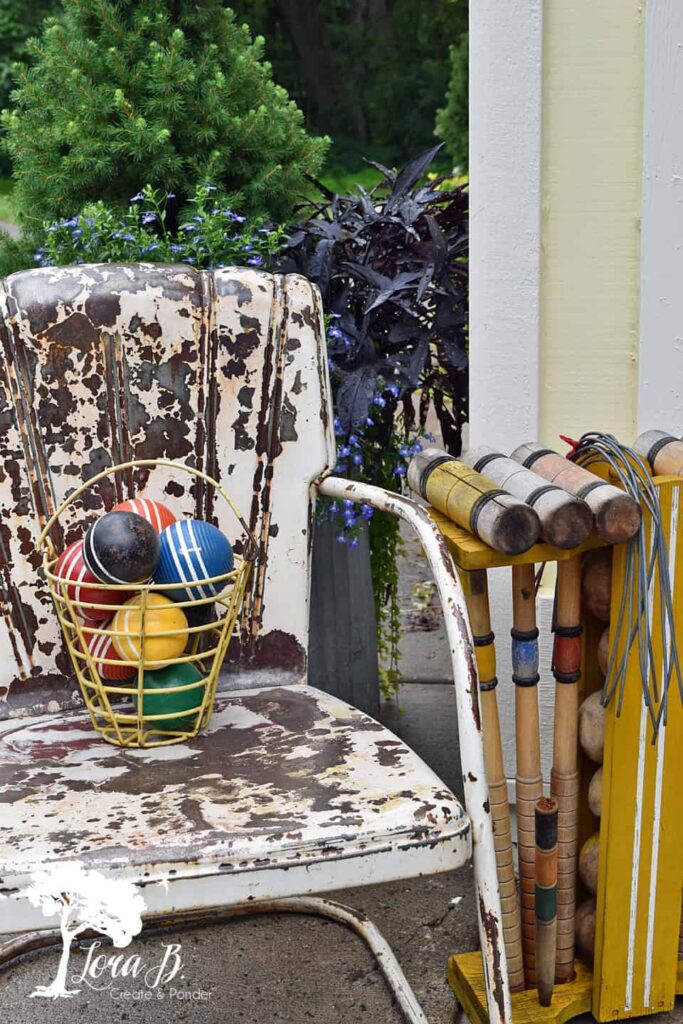 Vintage chippy chair with croquet mallets and balls.