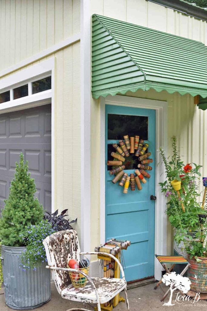 Vintage Croquet-Mallet-Wreath on blue door with rustic charm.