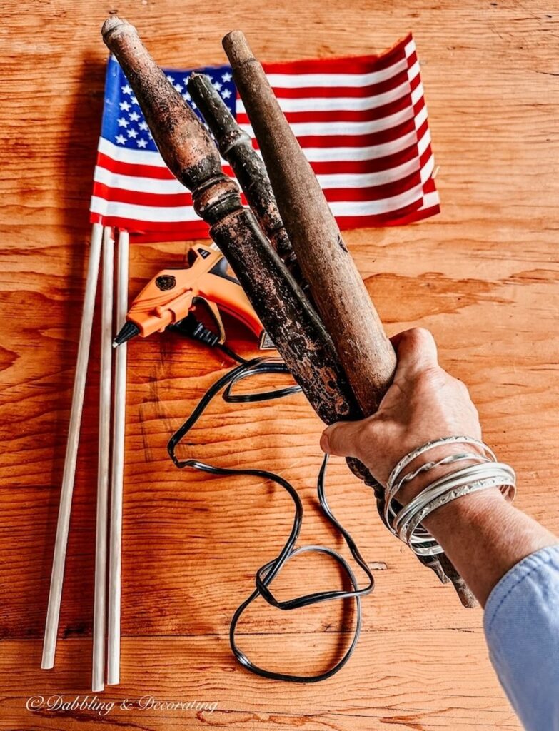 Three Antique Spindles in Hand with American Flags and Glue Gun