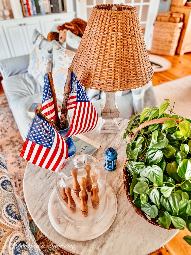 DIY American Flags made out of spindles in Vintage blue vase on table.