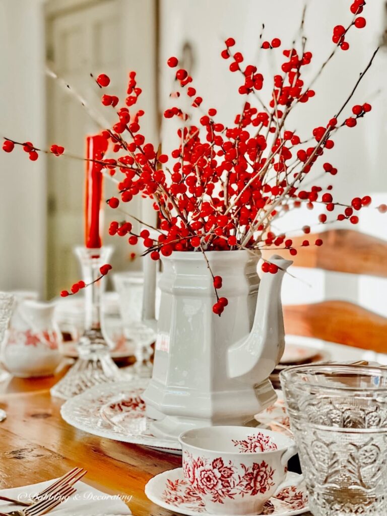 Red Winterberries in vintage accent pitcher on table setting centerpiece