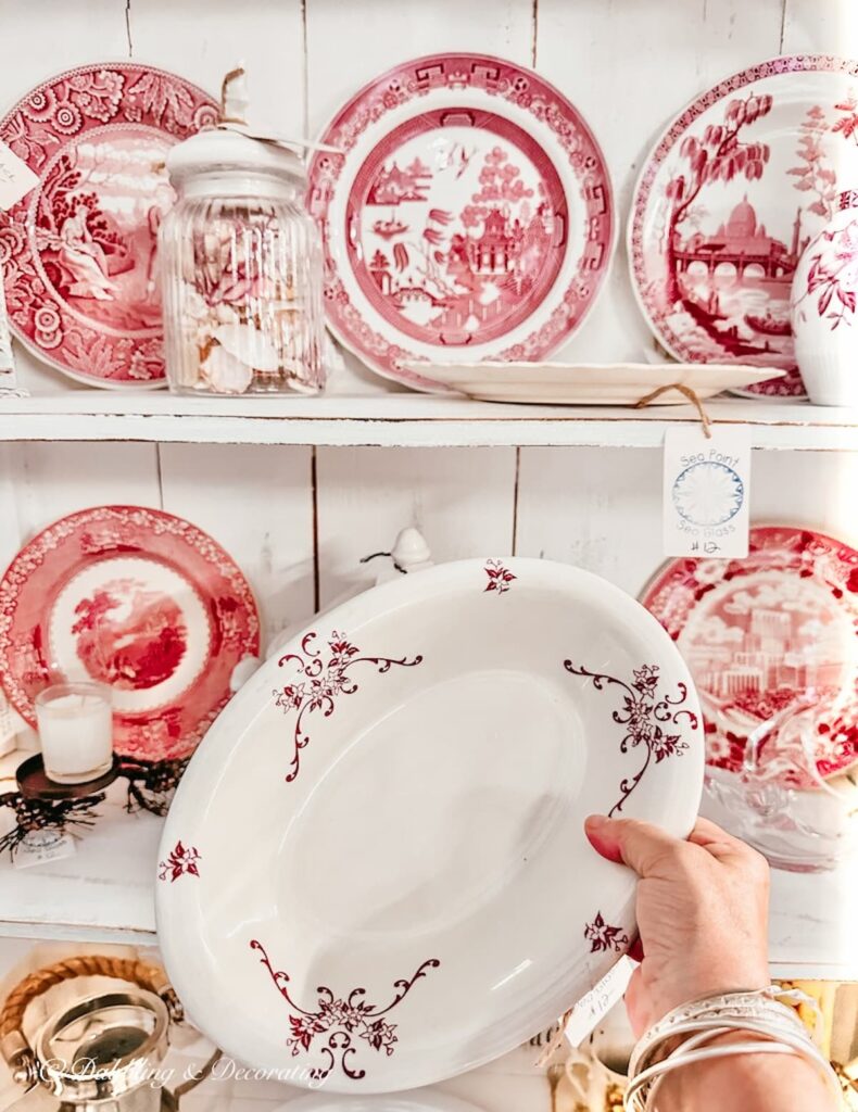 Vintage red and white dinnerware and platters in white farmhouse hutch