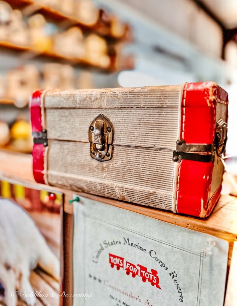 Vintage suitcase with red accents in antique shop.