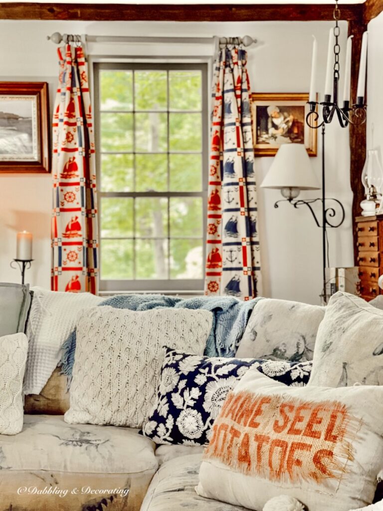 Living room with coastal curtains and cozy sofa with pillows and vintage decor.