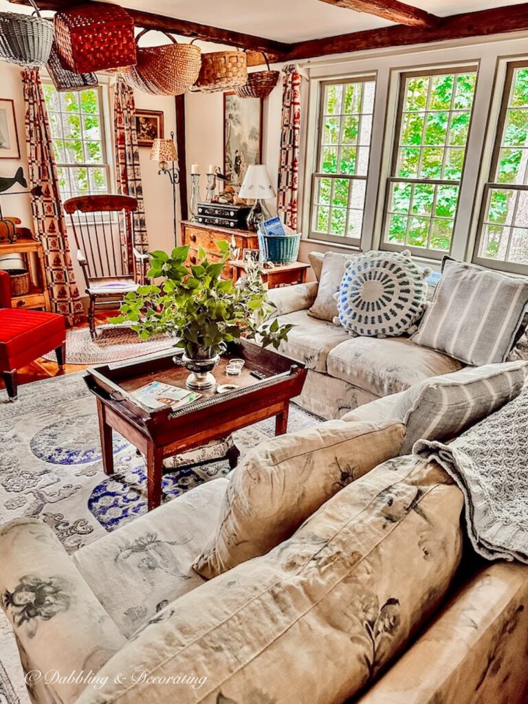 cozy vintage inspired living room with hanging antique baskets on ceiling wooden beam.