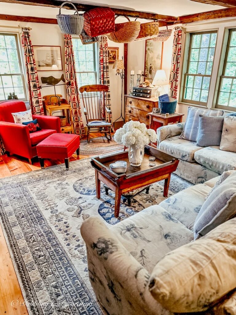 Vintage living room with hanging antique baskets from ceiling beam for a primitive look.