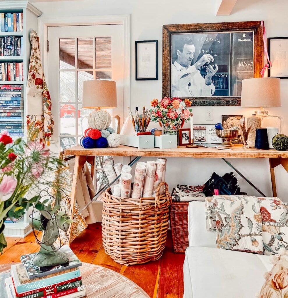 Large Basket with Wallpaper samples in craft room space under table.