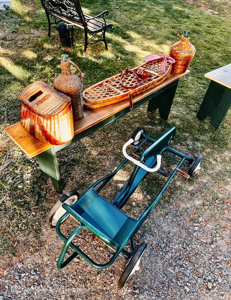 Vintage fishing reel basket, Demijohn, snowshoes and pedal cart at barn sale.