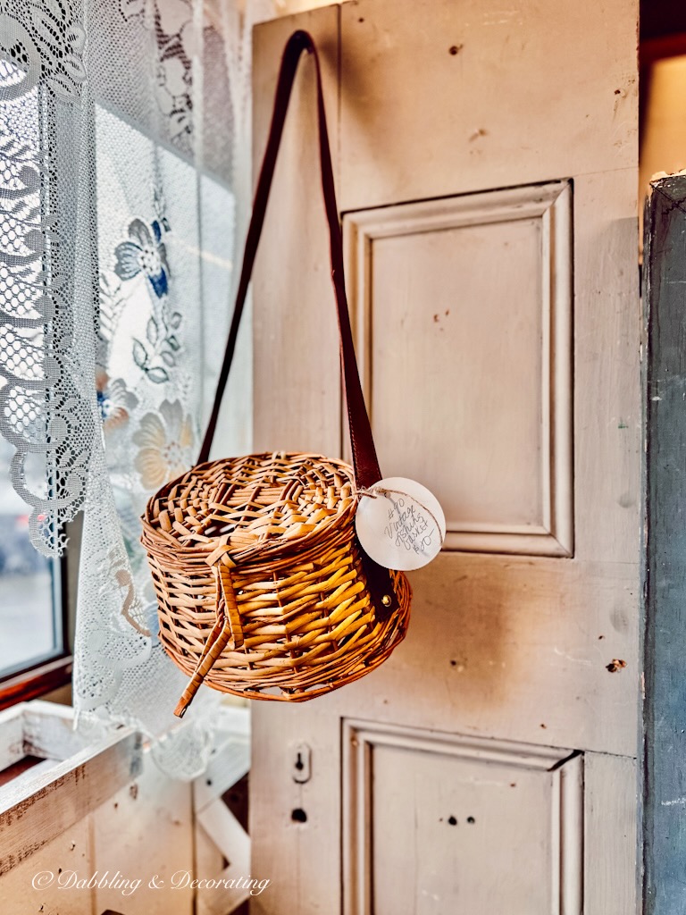 Vintage Fishing creel basket hanging in antique store on old door.